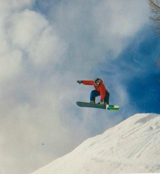 Sax on a snowboard doing a trick